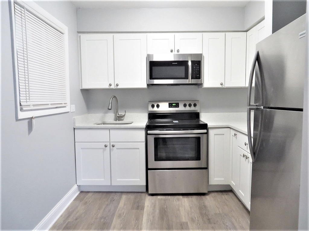1050 North Wheeling Road, Unit 2B Mount Prospect, IL 60056 - Photo 2 of 13 a kitchen with stainless steel appliances a refrigerator stove and microwave