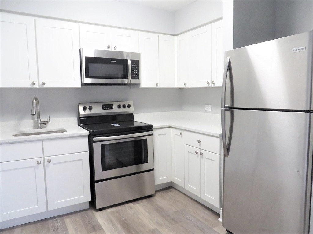 1050 North Wheeling Road, Unit 2B Mount Prospect, IL 60056 - Photo 3 of 13 a white refrigerator freezer sitting inside of a kitchen