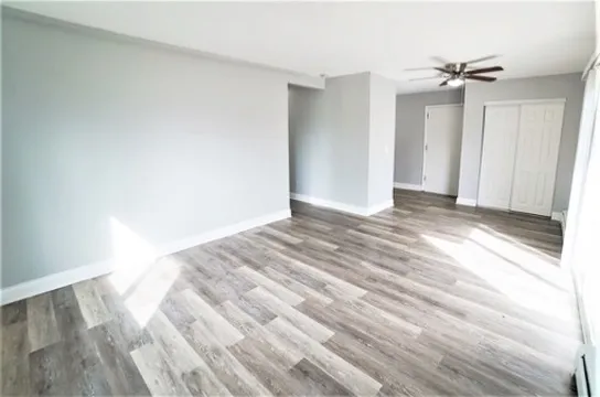 a view of a room with wooden floor and a ceiling fan