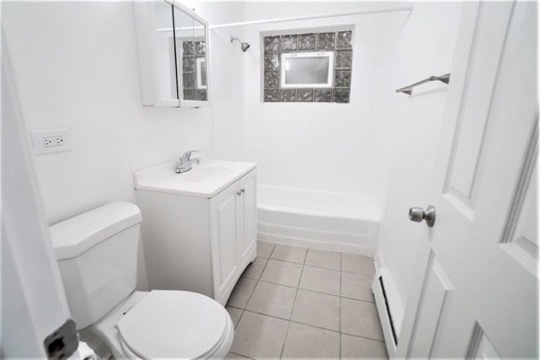 1050 North Wheeling Road, Unit 2B Mount Prospect, IL 60056 - Photo 8 of 13 a white toilet sitting next to a bathroom sink