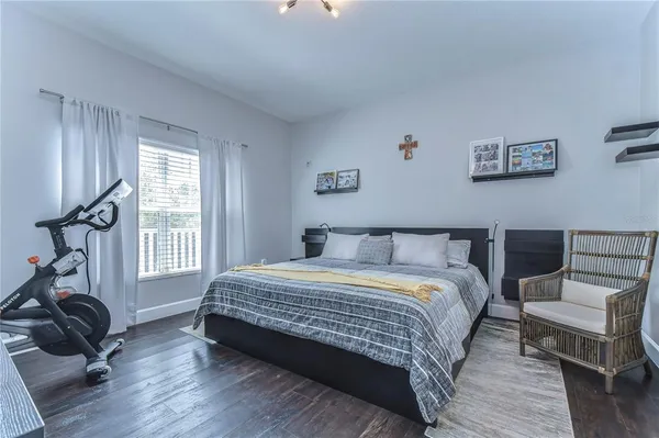 a bedroom with a bed a couch and large window