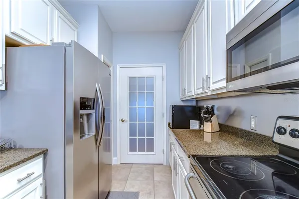 a kitchen with stainless steel appliances granite countertop a refrigerator and a stove top oven