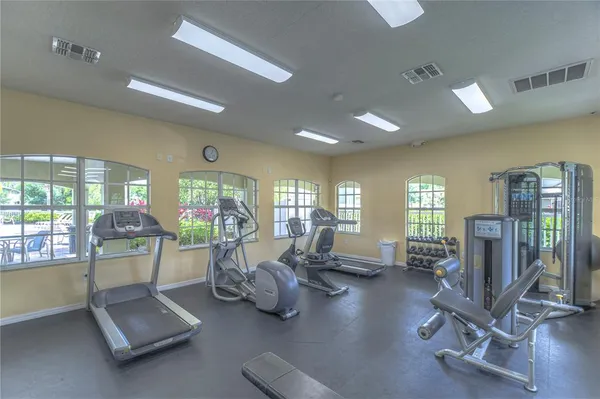 a room with gym equipment and large windows