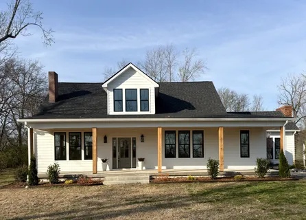 a living room with furniture a chandelier and a fireplace