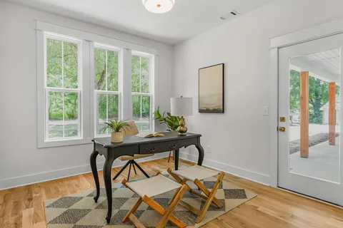 an empty room with fan and wooden floor