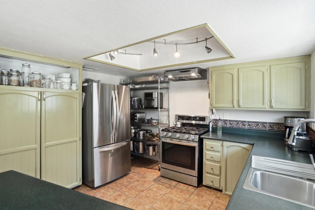 3340 Skytrail Ranch Road Jamul, CA 91935 - Photo 20 of 42 a kitchen with stainless steel appliances granite countertop a refrigerator and a stove