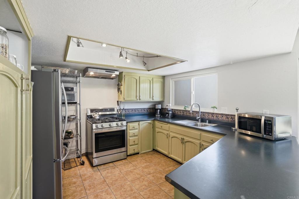 3340 Skytrail Ranch Road Jamul, CA 91935 - Photo 21 of 42 a kitchen with stainless steel appliances granite countertop a stove and a refrigerator