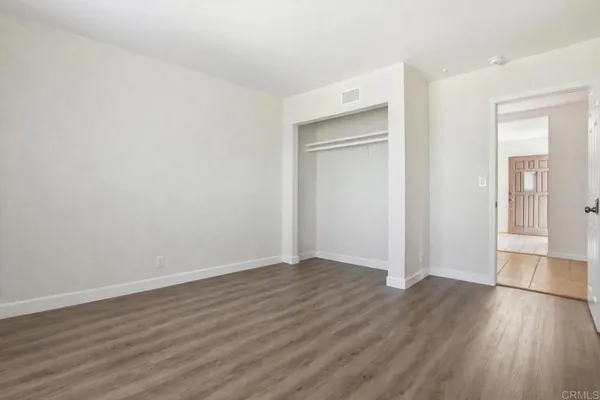 a room with a bed and a wooden floor