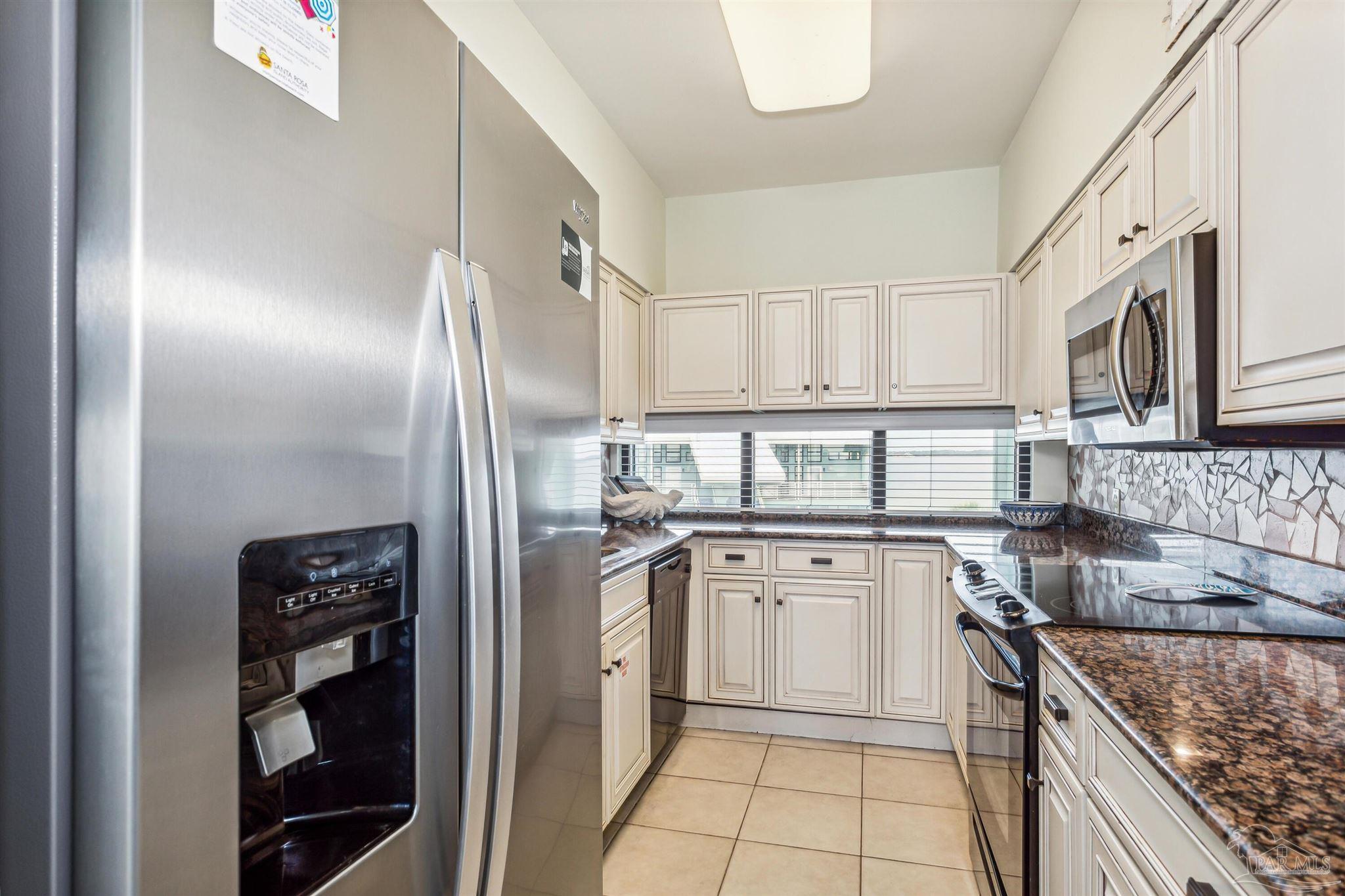 1390 Fort Pickens Road, Unit 229 Pensacola Beach, FL 32561 - Photo 17 of 47 a kitchen with stainless steel appliances granite countertop a sink stove and refrigerator
