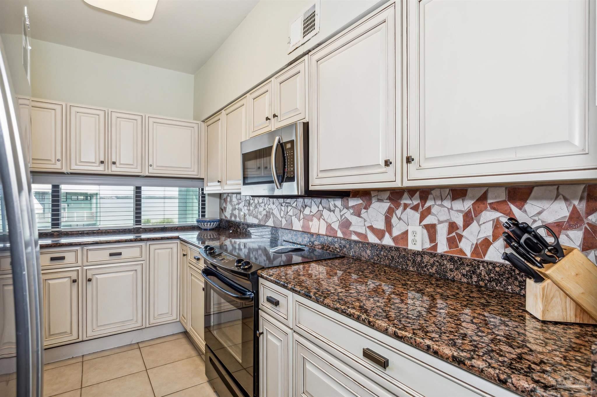 1390 Fort Pickens Road, Unit 229 Pensacola Beach, FL 32561 - Photo 19 of 47 a kitchen with white cabinets