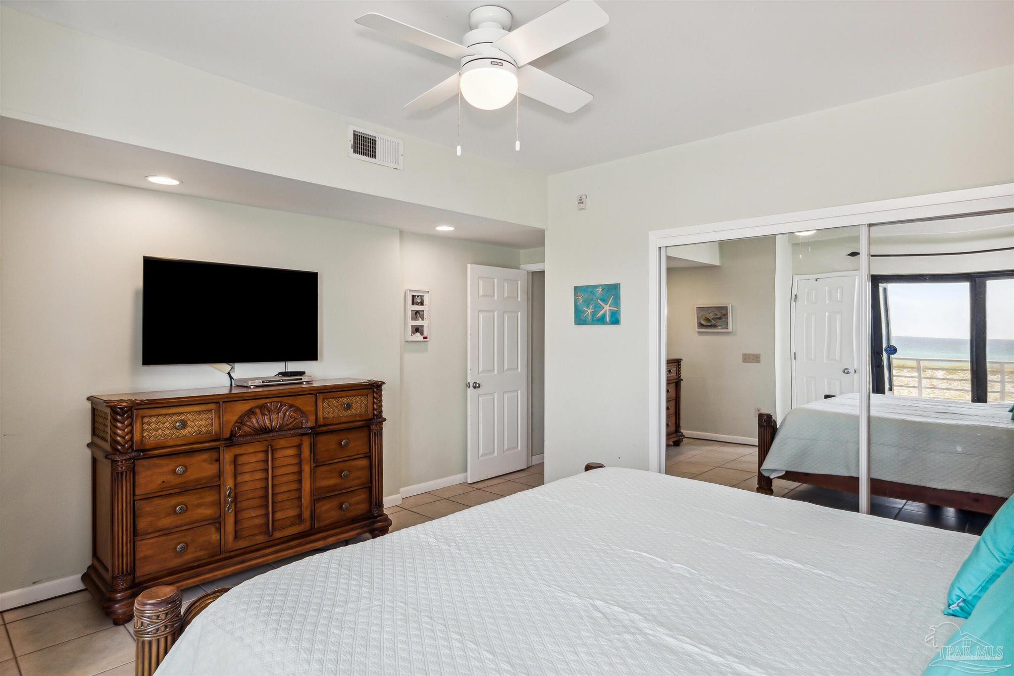 1390 Fort Pickens Road, Unit 229 Pensacola Beach, FL 32561 - Photo 22 of 47 a bedroom with a bed and a flat screen tv