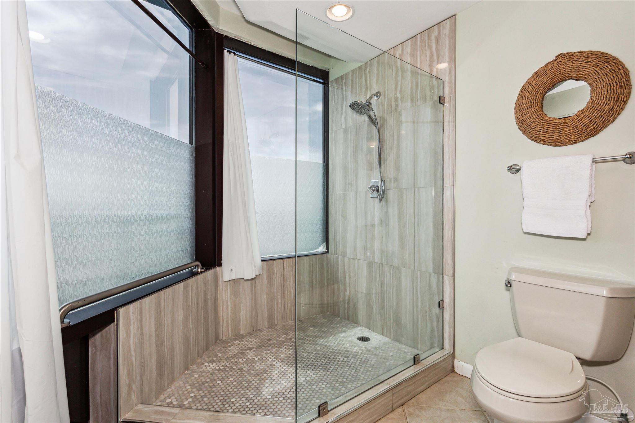 1390 Fort Pickens Road, Unit 229 Pensacola Beach, FL 32561 - Photo 23 of 47 a bathroom with a shower a toilet and a sink