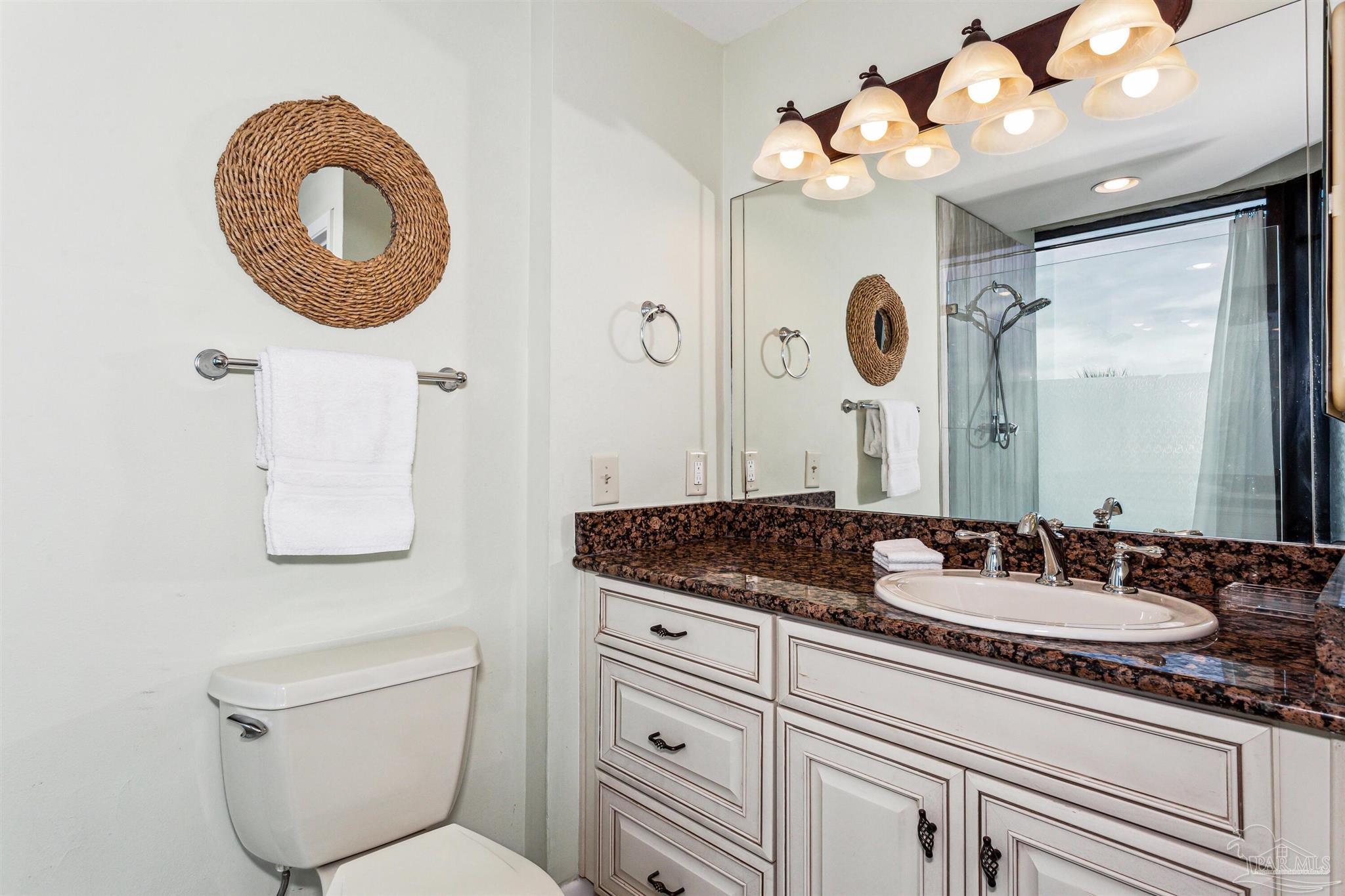 1390 Fort Pickens Road, Unit 229 Pensacola Beach, FL 32561 - Photo 24 of 47 a bathroom with a toilet a sink and a mirror