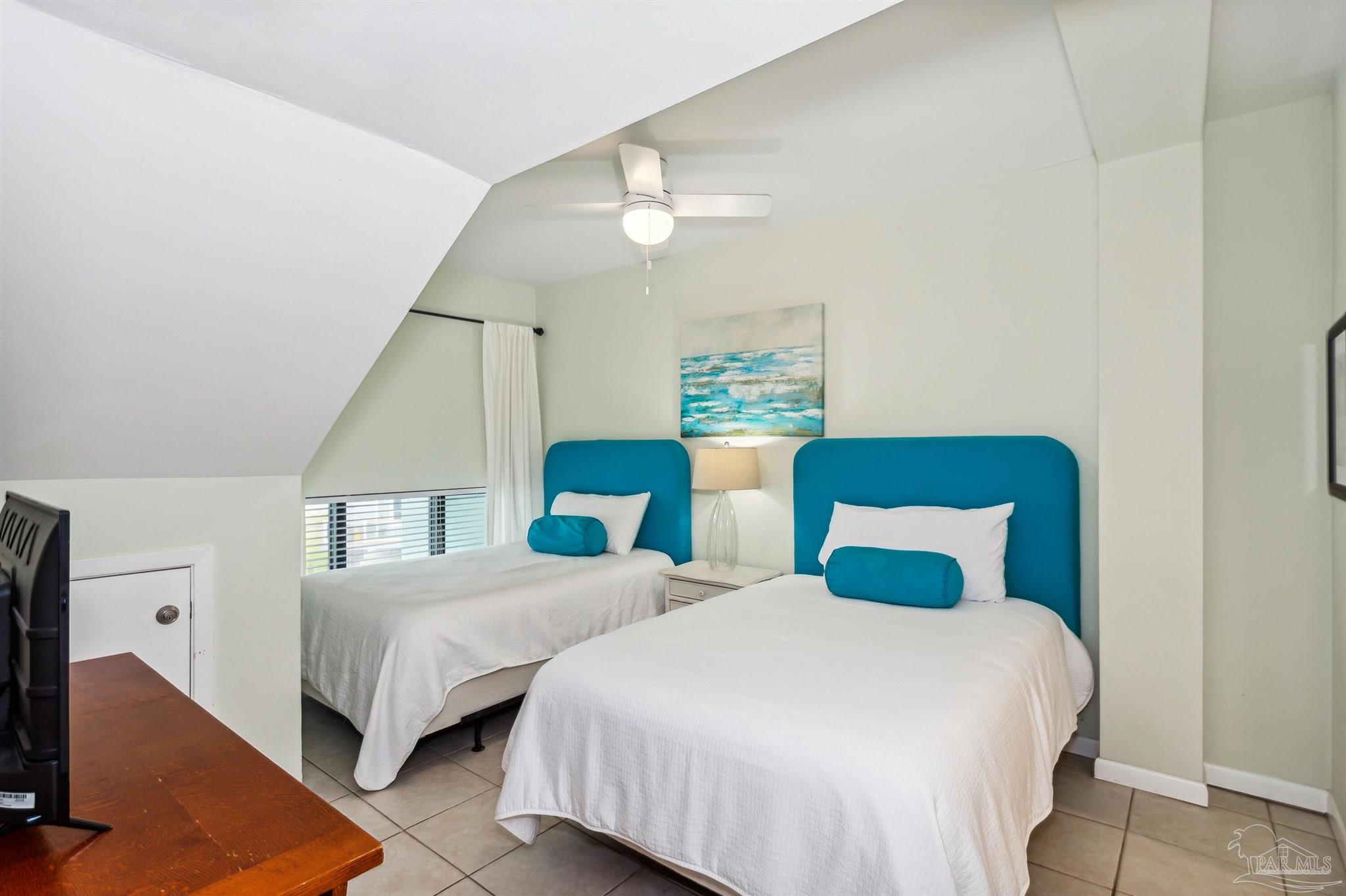 1390 Fort Pickens Road, Unit 229 Pensacola Beach, FL 32561 - Photo 25 of 47 a bedroom with two beds and a chandelier