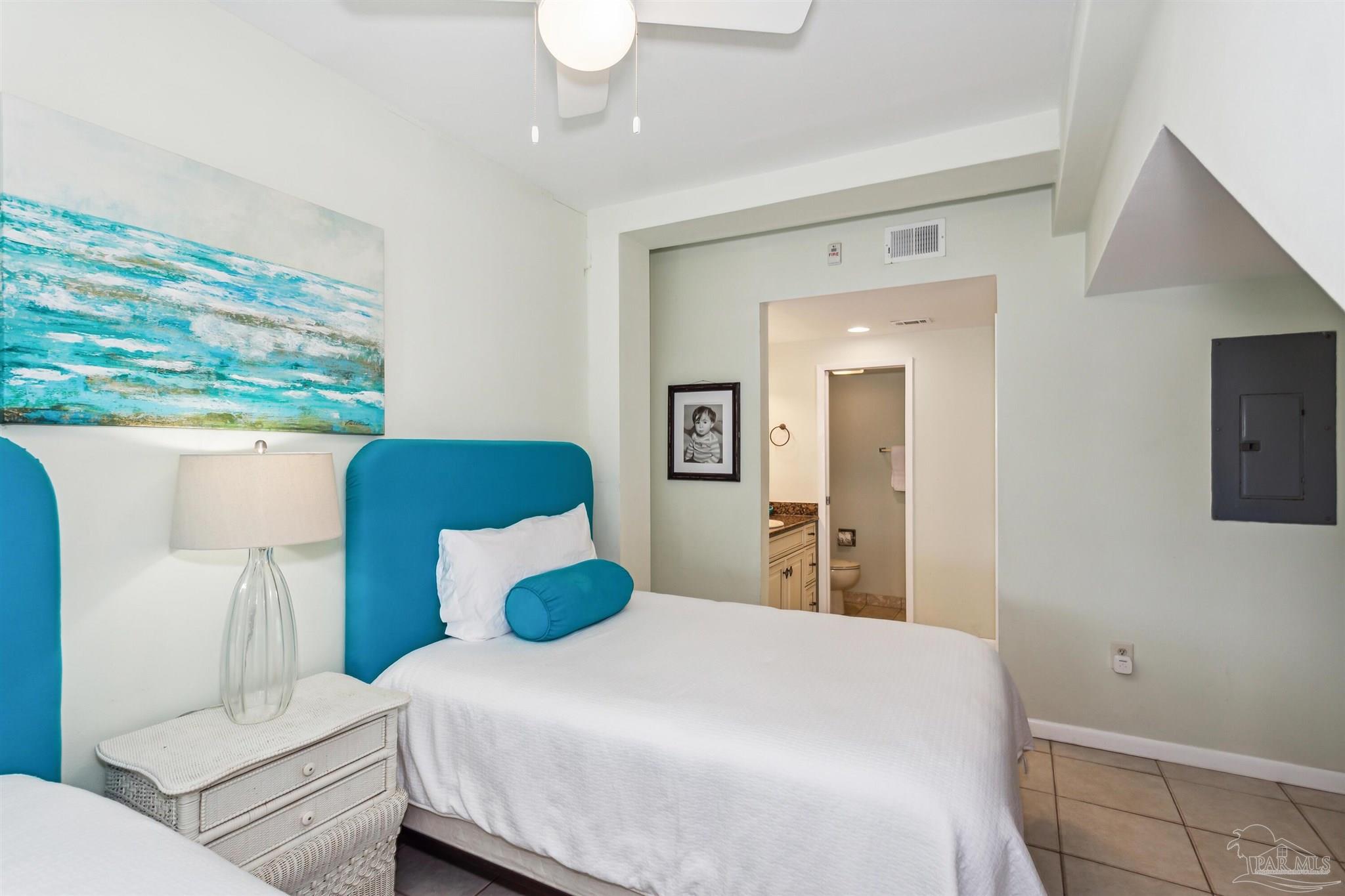 1390 Fort Pickens Road, Unit 229 Pensacola Beach, FL 32561 - Photo 27 of 47 a bedroom with a large bed and a chandelier