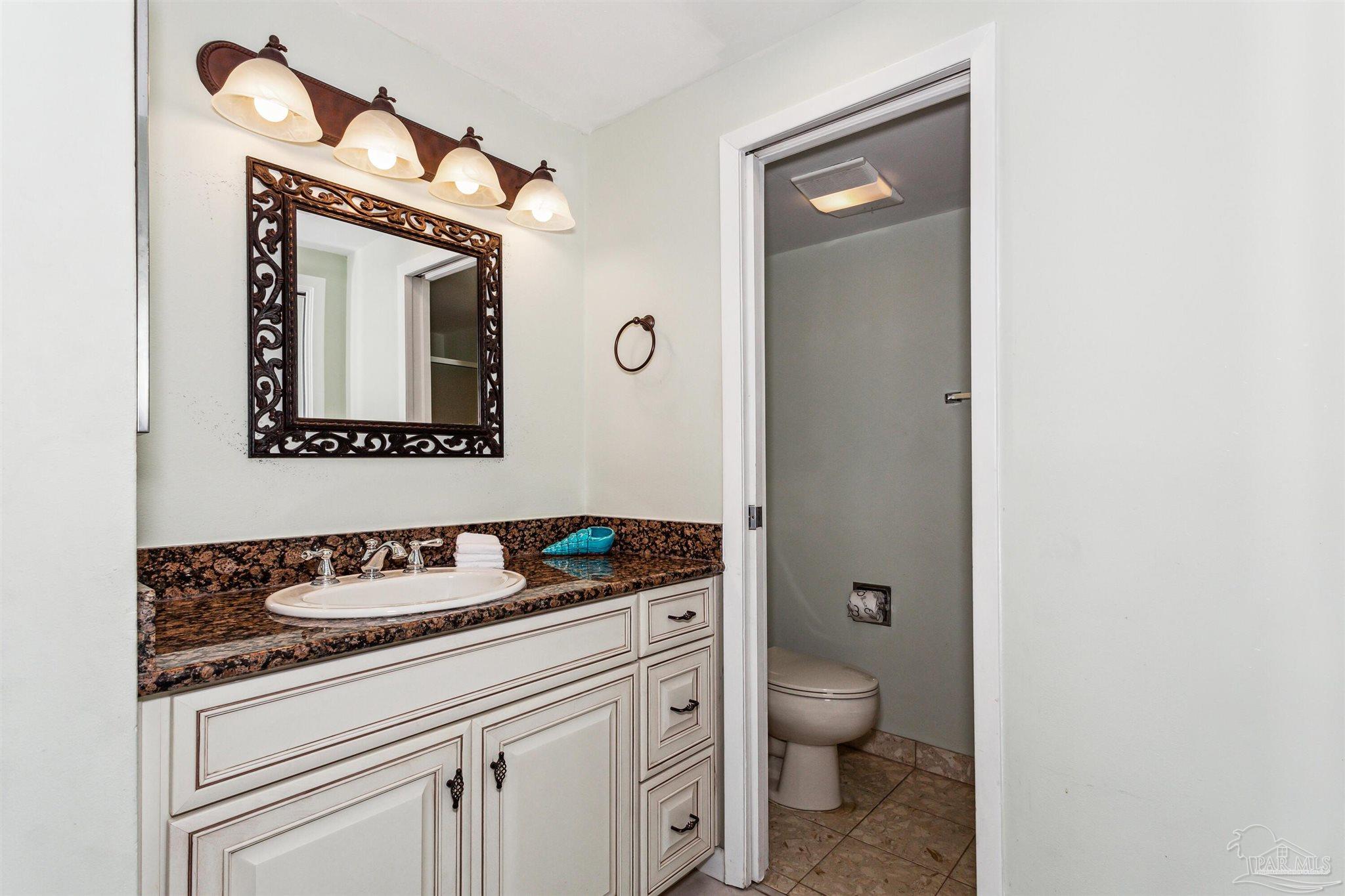 1390 Fort Pickens Road, Unit 229 Pensacola Beach, FL 32561 - Photo 28 of 47 a bathroom with a toilet sink and mirror
