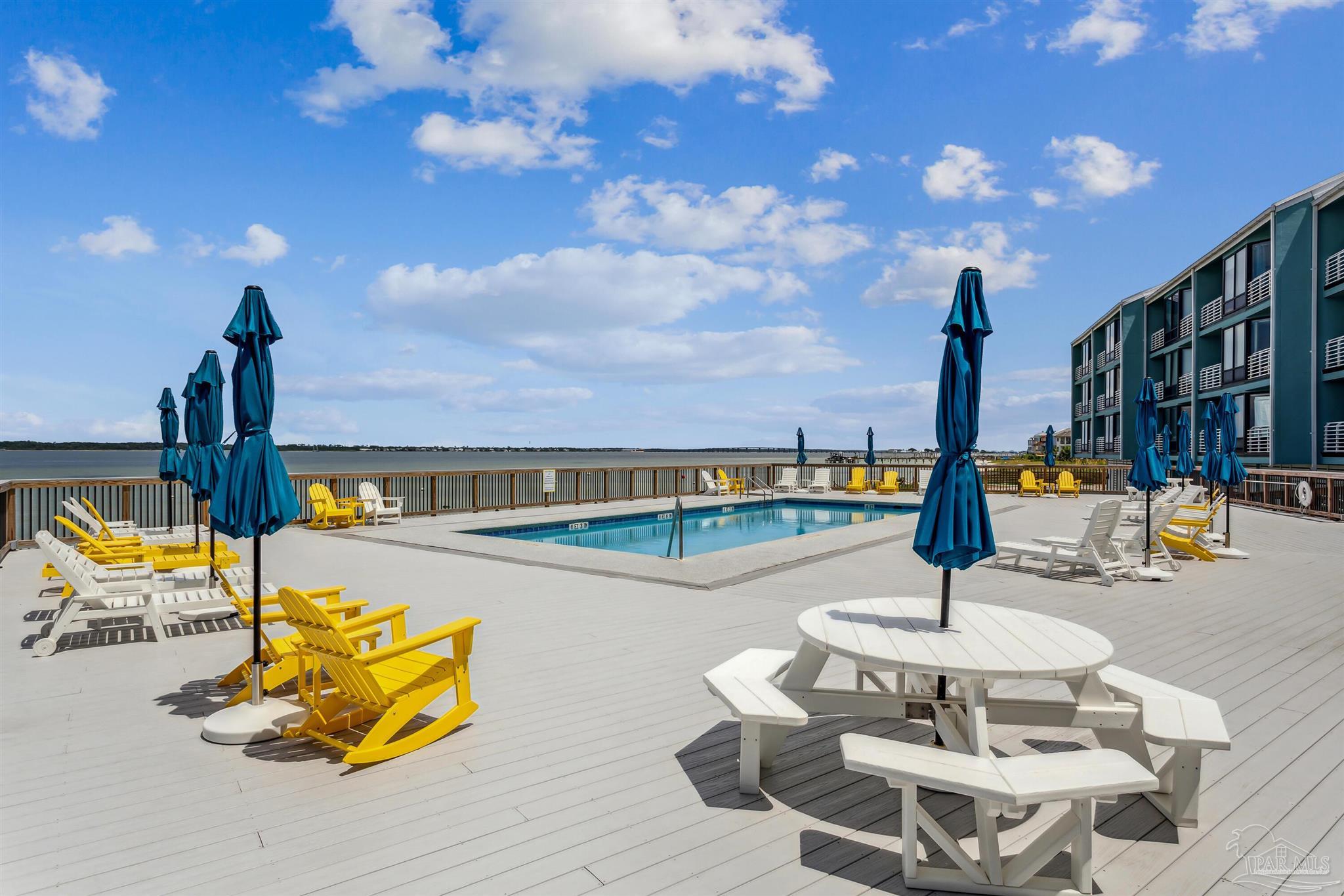 1390 Fort Pickens Road, Unit 229 Pensacola Beach, FL 32561 - Photo 34 of 47 a view of a swimming pool with a table and chairs