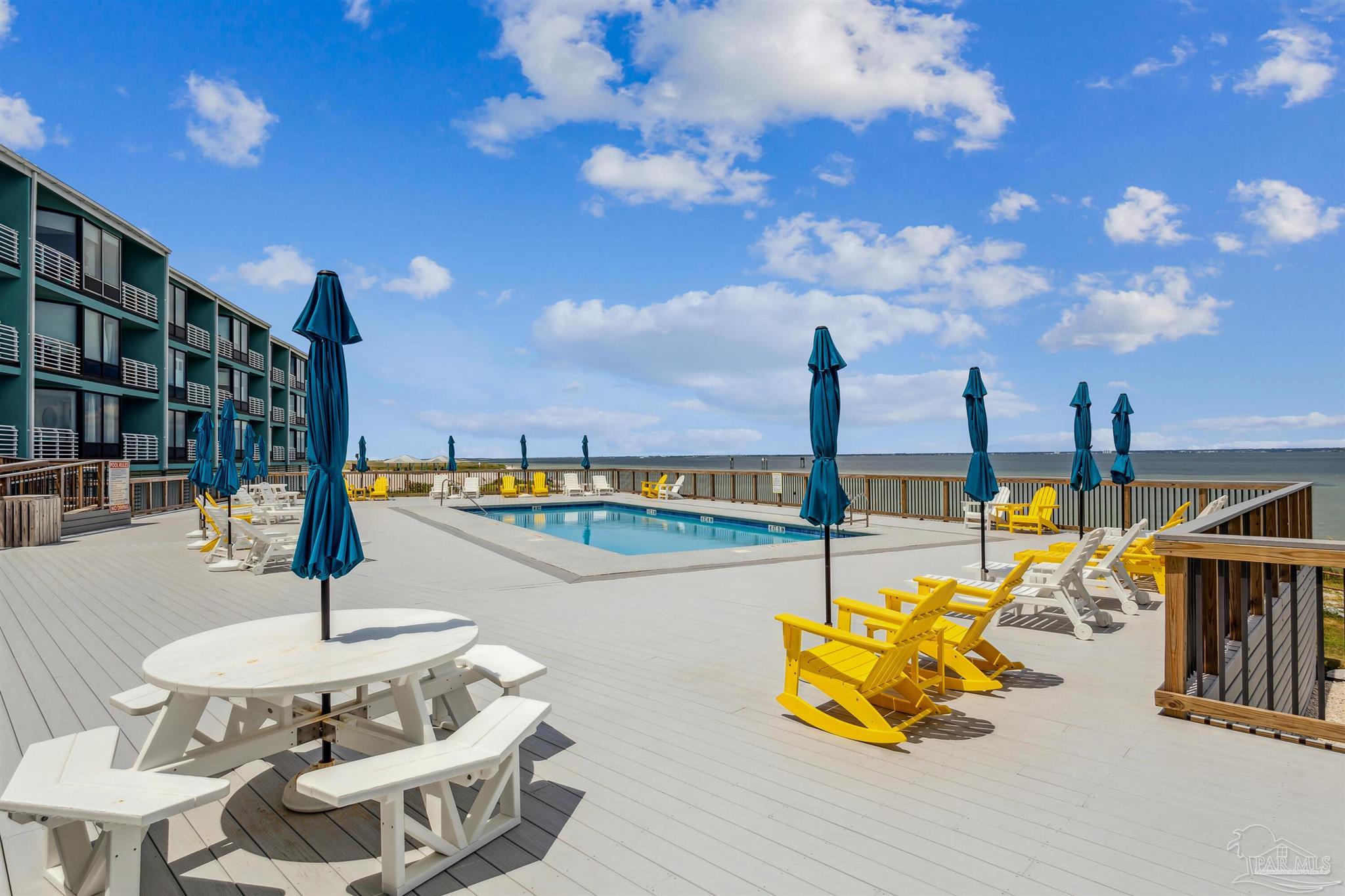 1390 Fort Pickens Road, Unit 229 Pensacola Beach, FL 32561 - Photo 35 of 47 a view of a swimming pool with a table and chairs