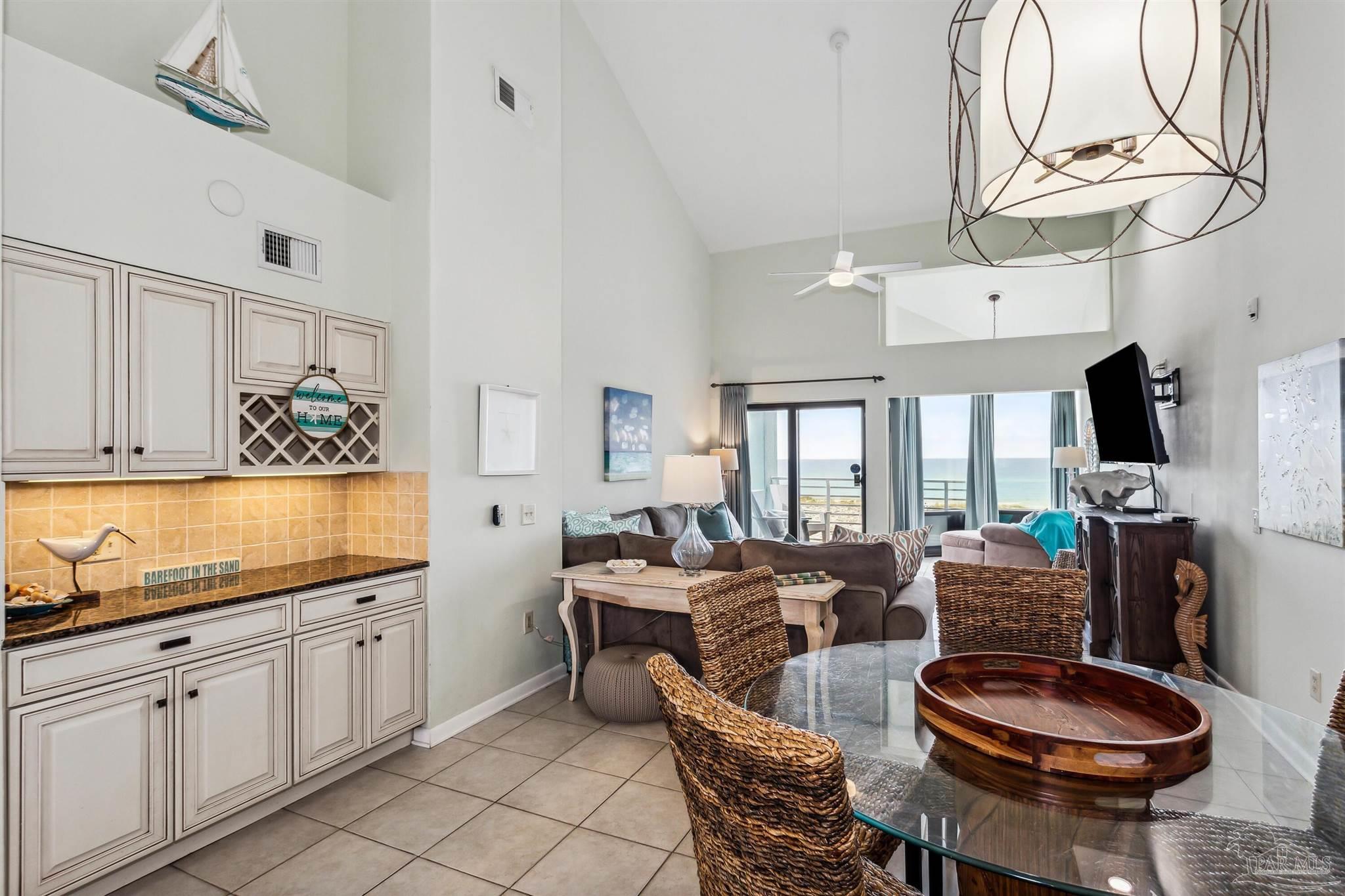 1390 Fort Pickens Road, Unit 229 Pensacola Beach, FL 32561 - Photo 6 of 47 a living room with furniture a flat screen tv and a floor to ceiling window