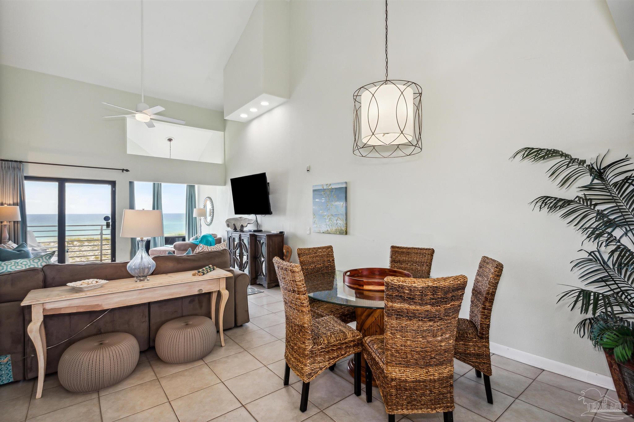 1390 Fort Pickens Road, Unit 229 Pensacola Beach, FL 32561 - Photo 7 of 47 a room with a table chairs and a flat screen tv