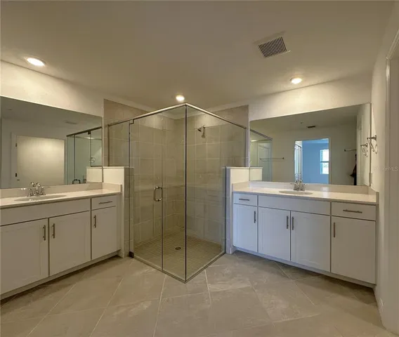 a bathroom with double sink and a mirror