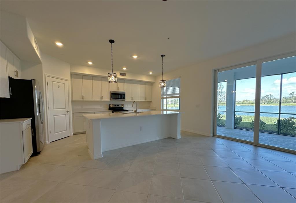 14149 Poppy Field Loop, Unit 6012 Punta Gorda, FL 33950 - Photo 3 of 49 a large kitchen with a large counter top appliances and cabinets