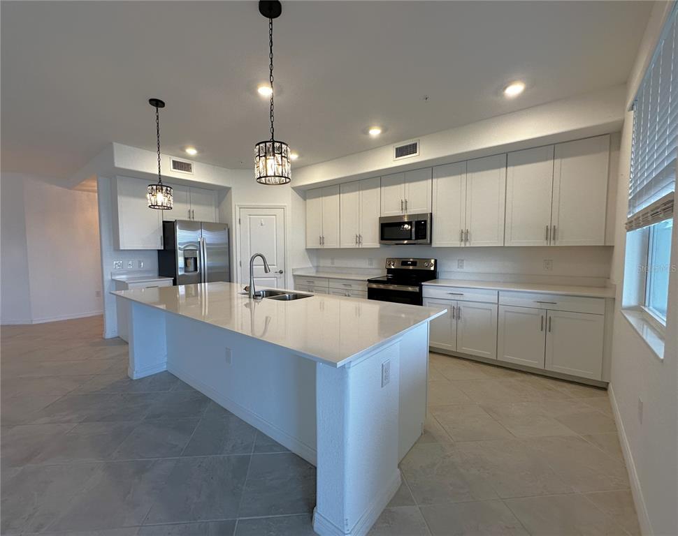 14149 Poppy Field Loop, Unit 6012 Punta Gorda, FL 33950 - Photo 4 of 49 a large kitchen with cabinets in it and stainless steel appliances