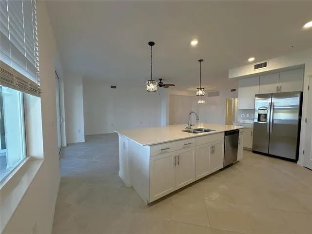 a kitchen with stainless steel appliances granite countertop a sink a refrigerator and a stove
