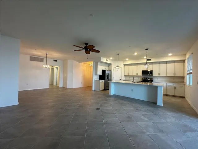 a view of kitchen with kitchen island stainless steel appliances cabinets and fireplace
