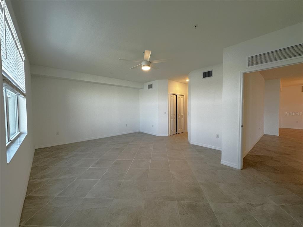 14149 Poppy Field Loop, Unit 6012 Punta Gorda, FL 33950 - Photo 10 of 49 an empty room with chandelier fan and windows