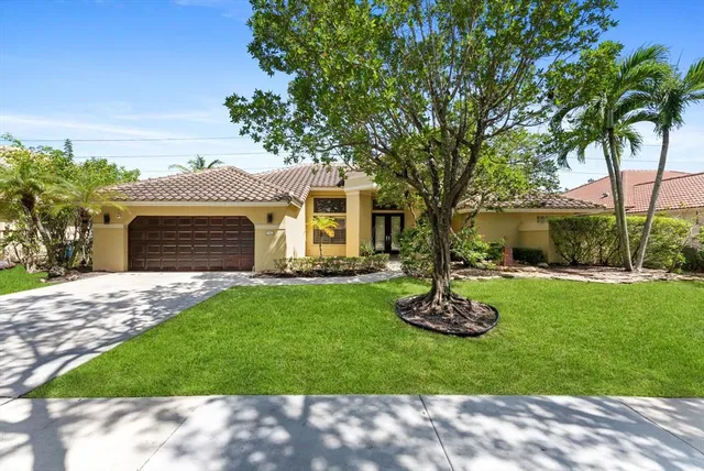 a front view of a house with a garden and yard