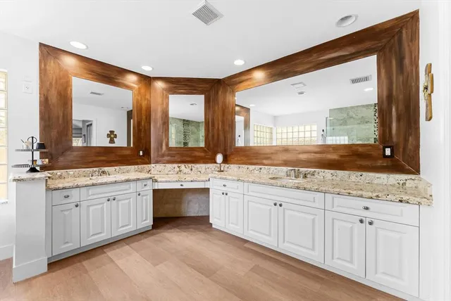 a bathroom with a double vanity sink mirror and toilet