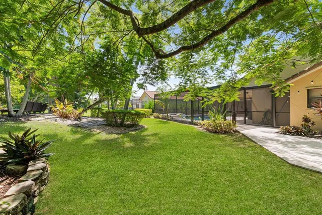 an aerial view of residential houses with outdoor space and trees