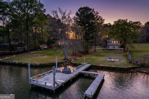 an aerial view of a house with swimming pool and a yard