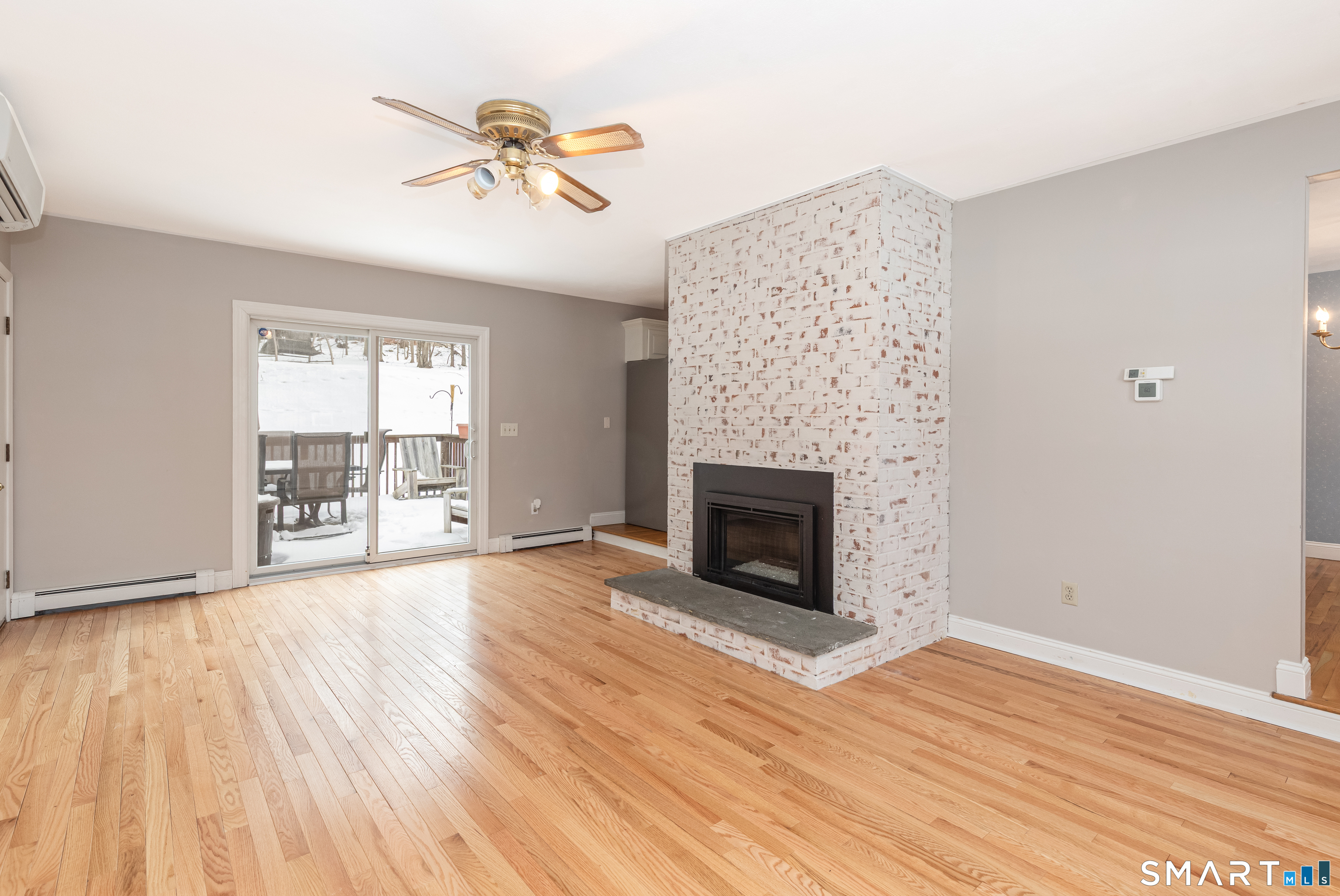 10 Apple Tree Road Bethel, CT 06801 - Photo 14 of 32 wooden floor fireplace and windows in an empty room