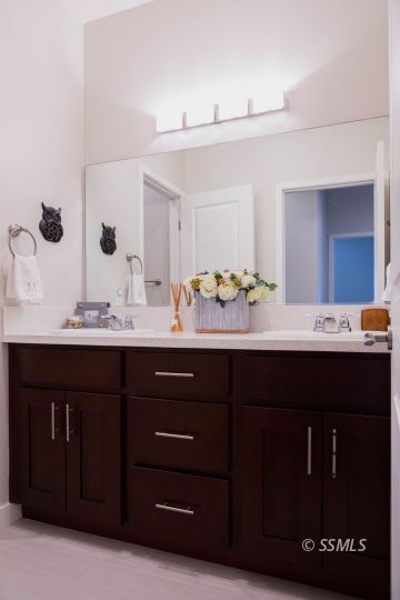 411 Abigail Street Ridgecrest, CA 93555 - Photo 28 of 39 a bathroom with a granite countertop sink and a mirror