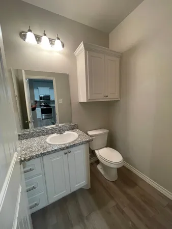 a bathroom with a granite countertop sink a toilet and a mirror