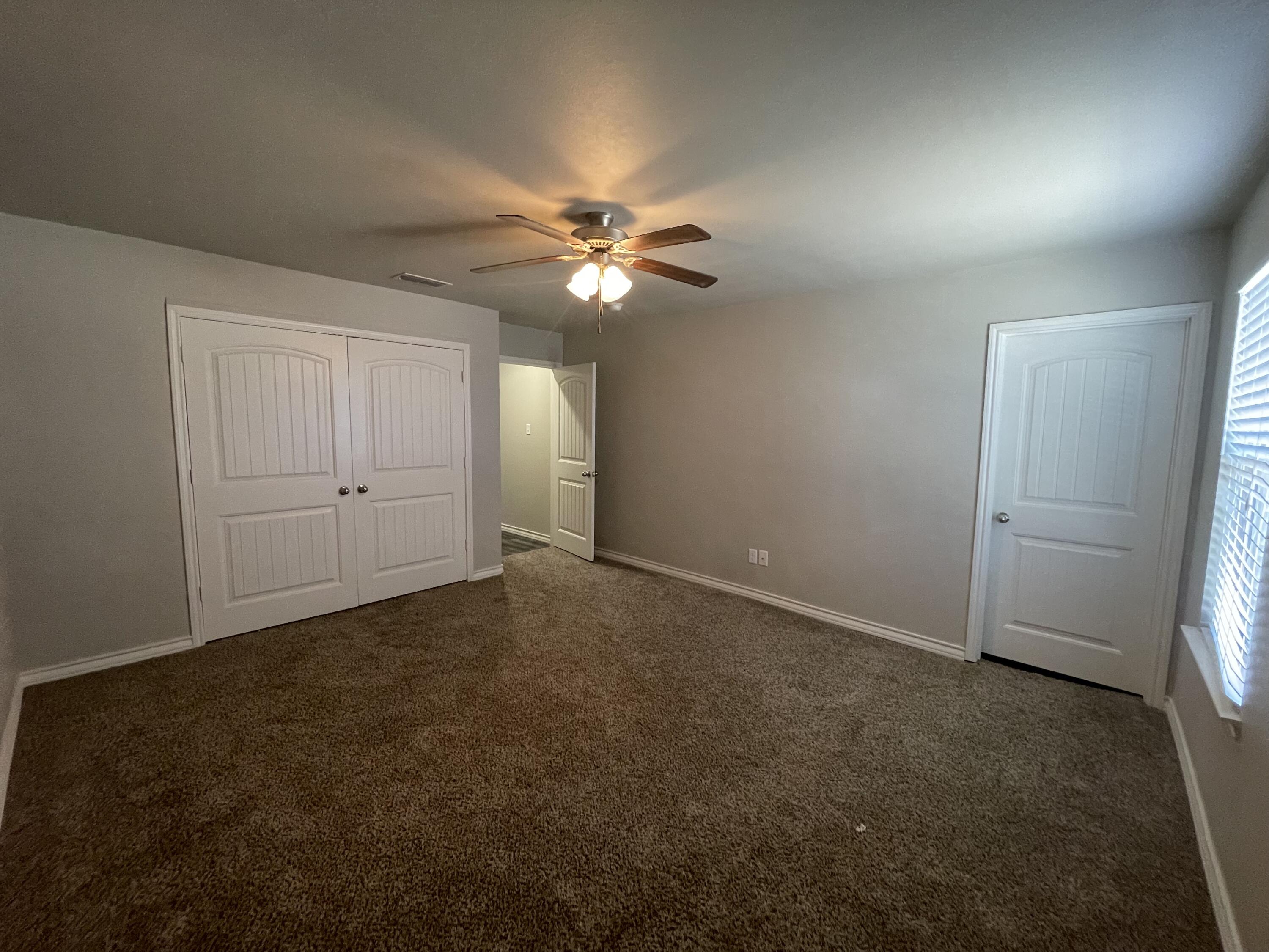 6040 24th Street, Unit 29 Lubbock, TX 79407 - Photo 10 of 15 an empty room with closet and a ceiling fan