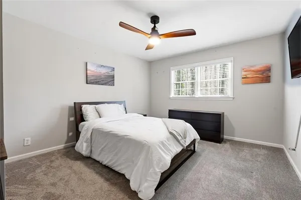 a bedroom with a bed and a ceiling fan