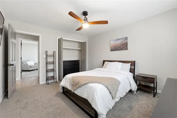 a spacious bedroom with a bed and a chandelier