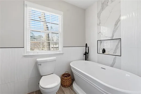 a white toilet sitting next to a bath tub