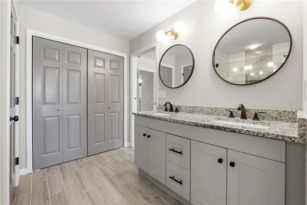 a bathroom with a granite countertop double vanity sink and a mirror