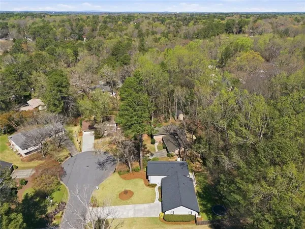 an aerial view of residential houses with outdoor space and trees
