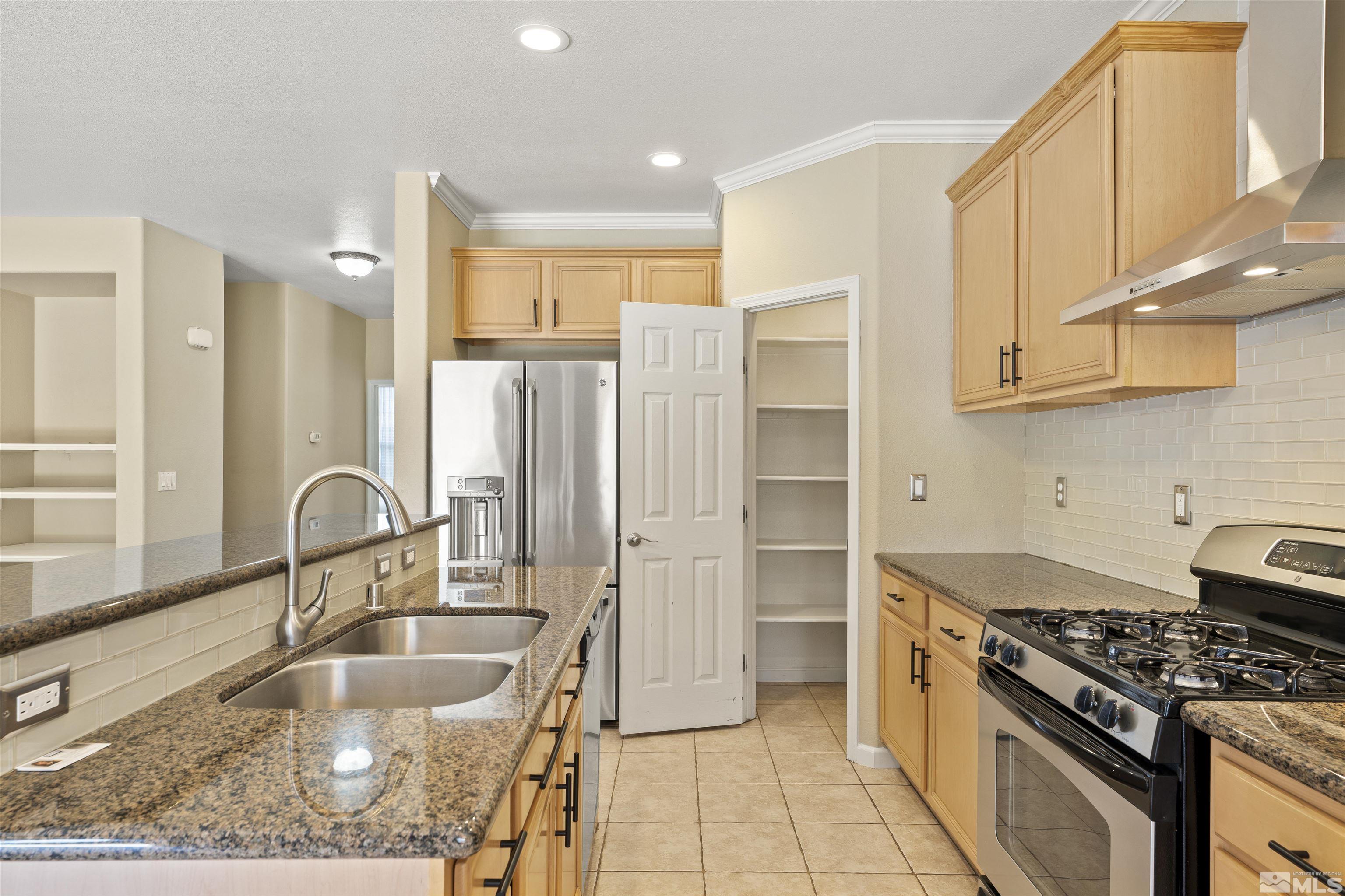 10200 Wolf Ridge Way Reno, NV 89521 - Photo 11 of 40 a kitchen with granite countertop a sink stainless steel appliances and cabinets