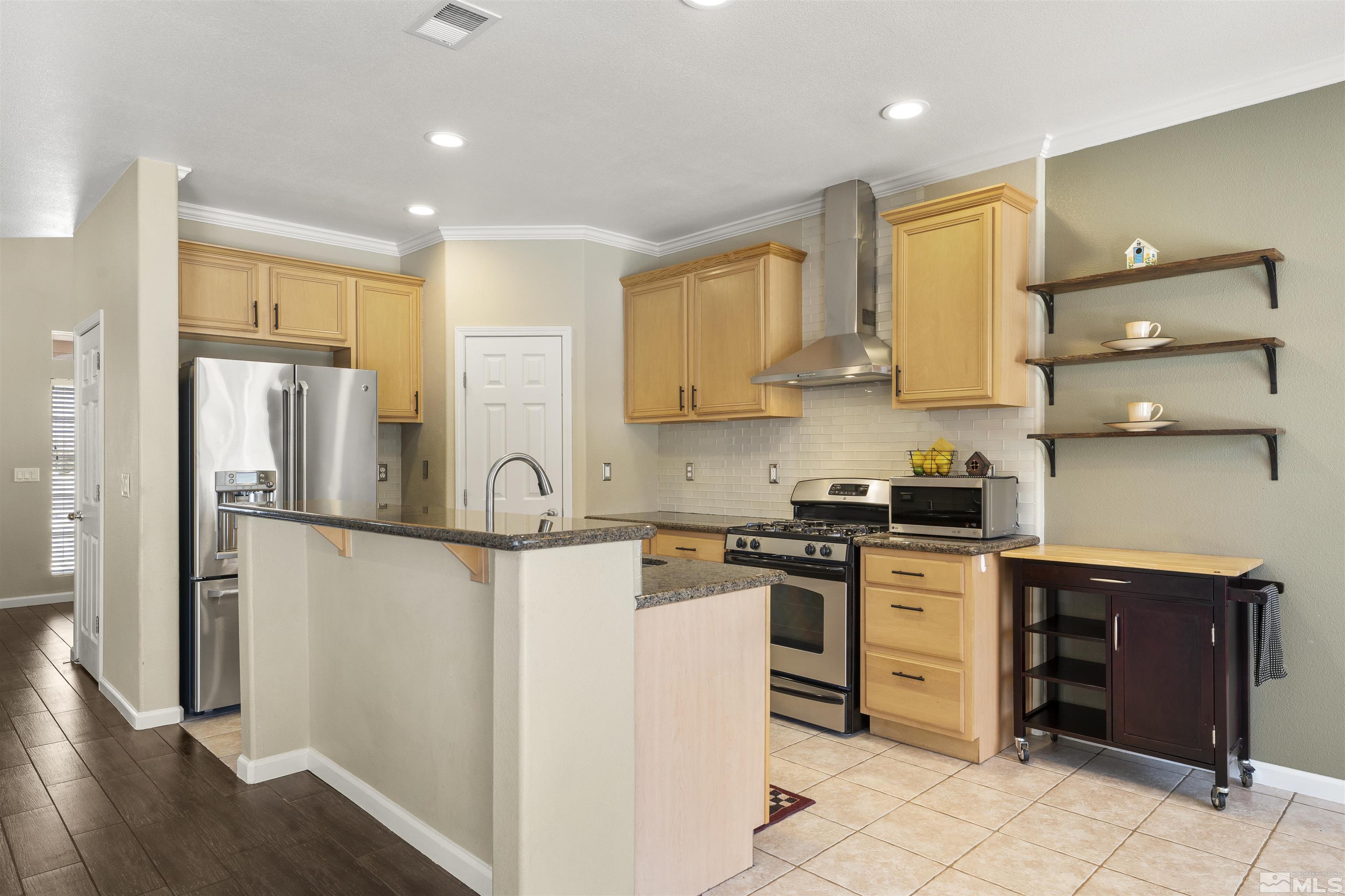 10200 Wolf Ridge Way Reno, NV 89521 - Photo 12 of 40 a kitchen with stainless steel appliances granite countertop a stove a refrigerator and a refrigerator