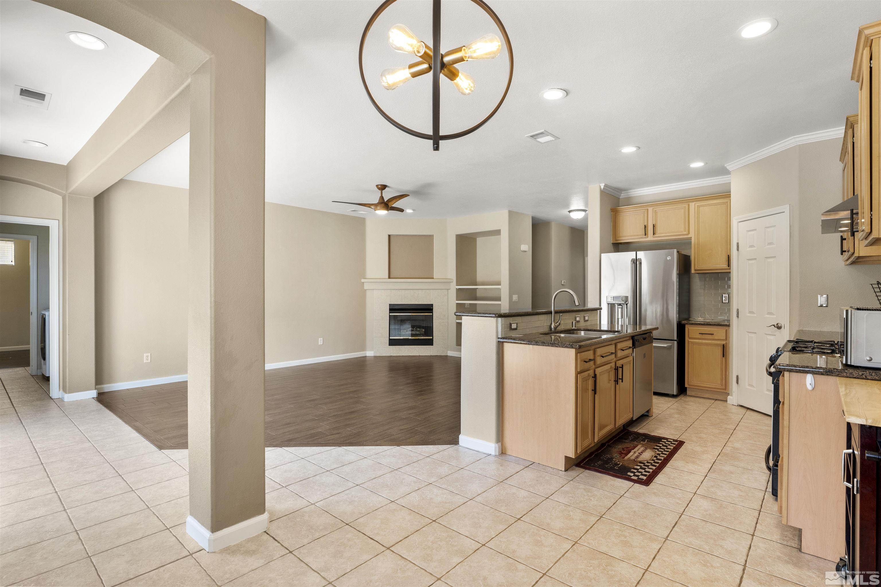 10200 Wolf Ridge Way Reno, NV 89521 - Photo 14 of 40 a kitchen with stainless steel appliances granite countertop a refrigerator and a sink