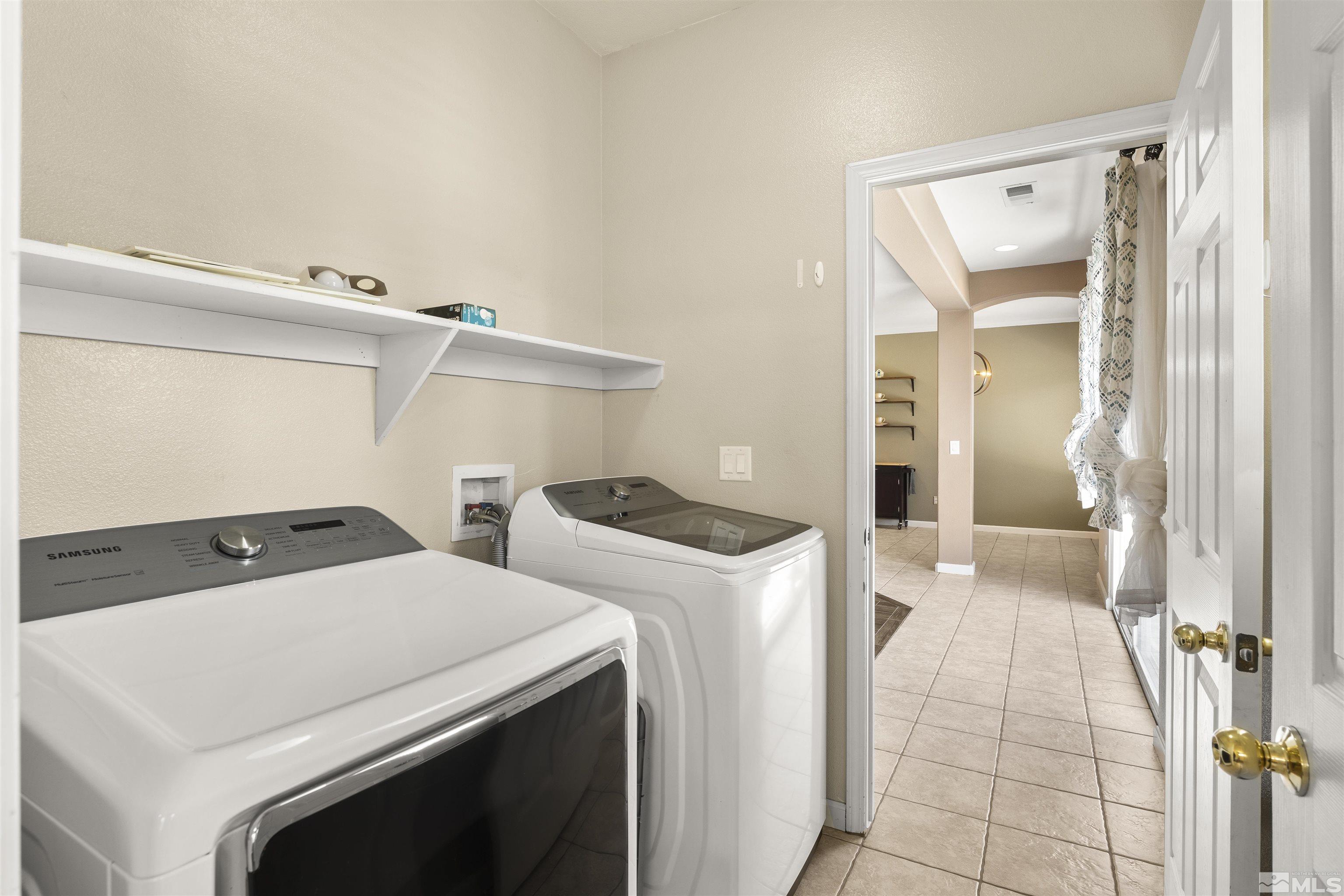 10200 Wolf Ridge Way Reno, NV 89521 - Photo 16 of 40 a view of washer and dryer with kitchen in the background
