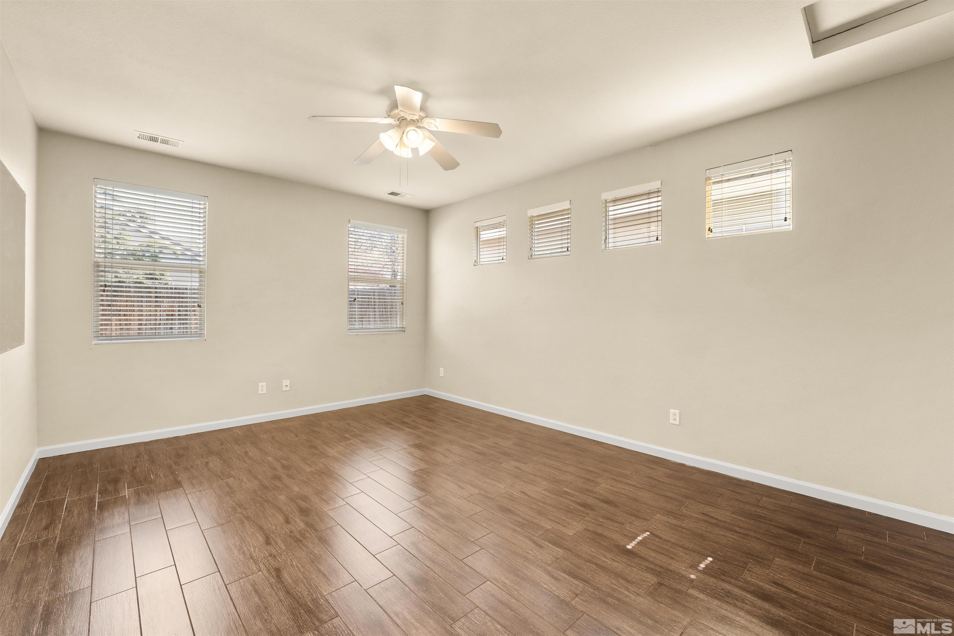 10200 Wolf Ridge Way Reno, NV 89521 - Photo 17 of 40 a view of an empty room with wooden floor and a window