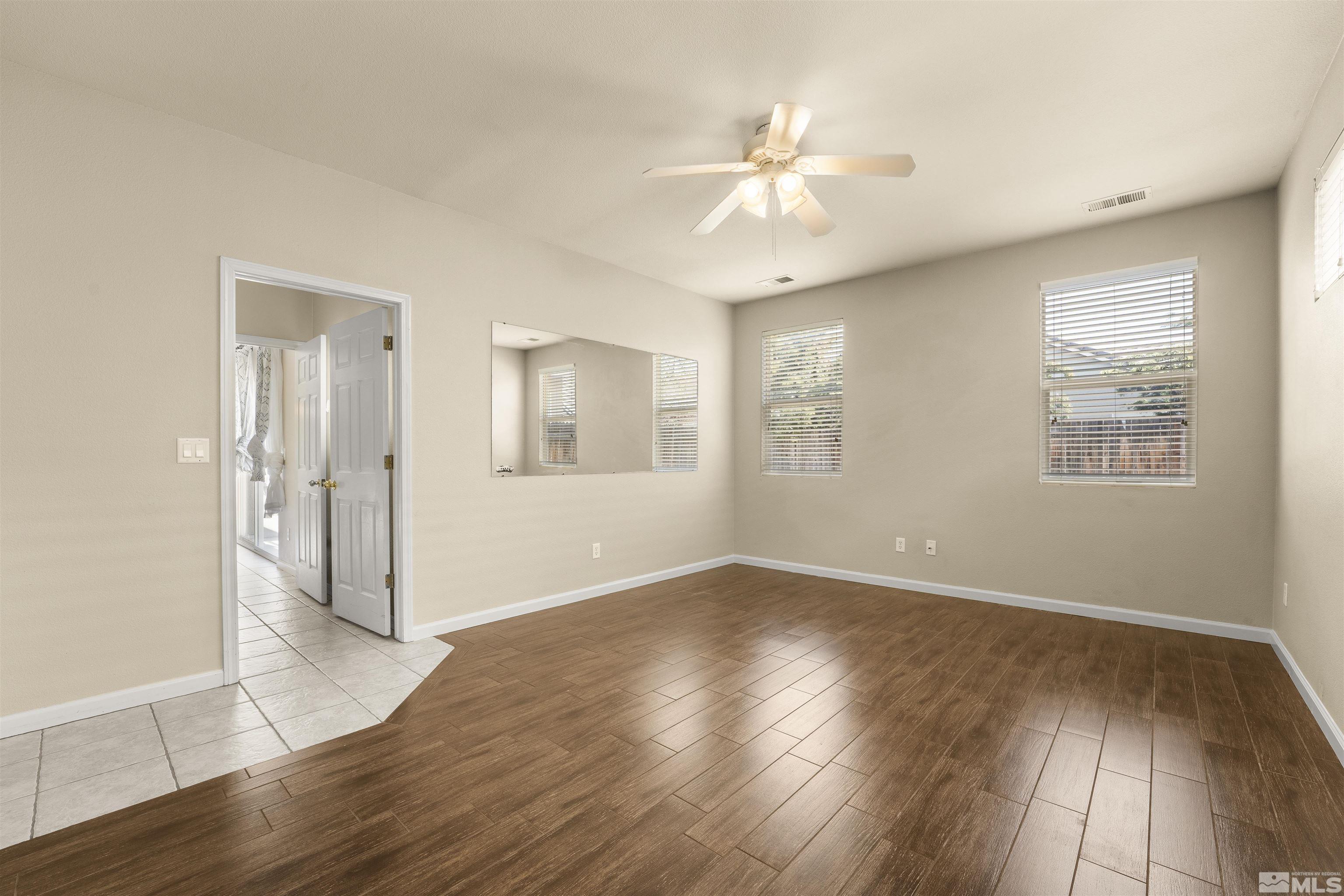 10200 Wolf Ridge Way Reno, NV 89521 - Photo 18 of 40 a view of an empty room with wooden floor and a window
