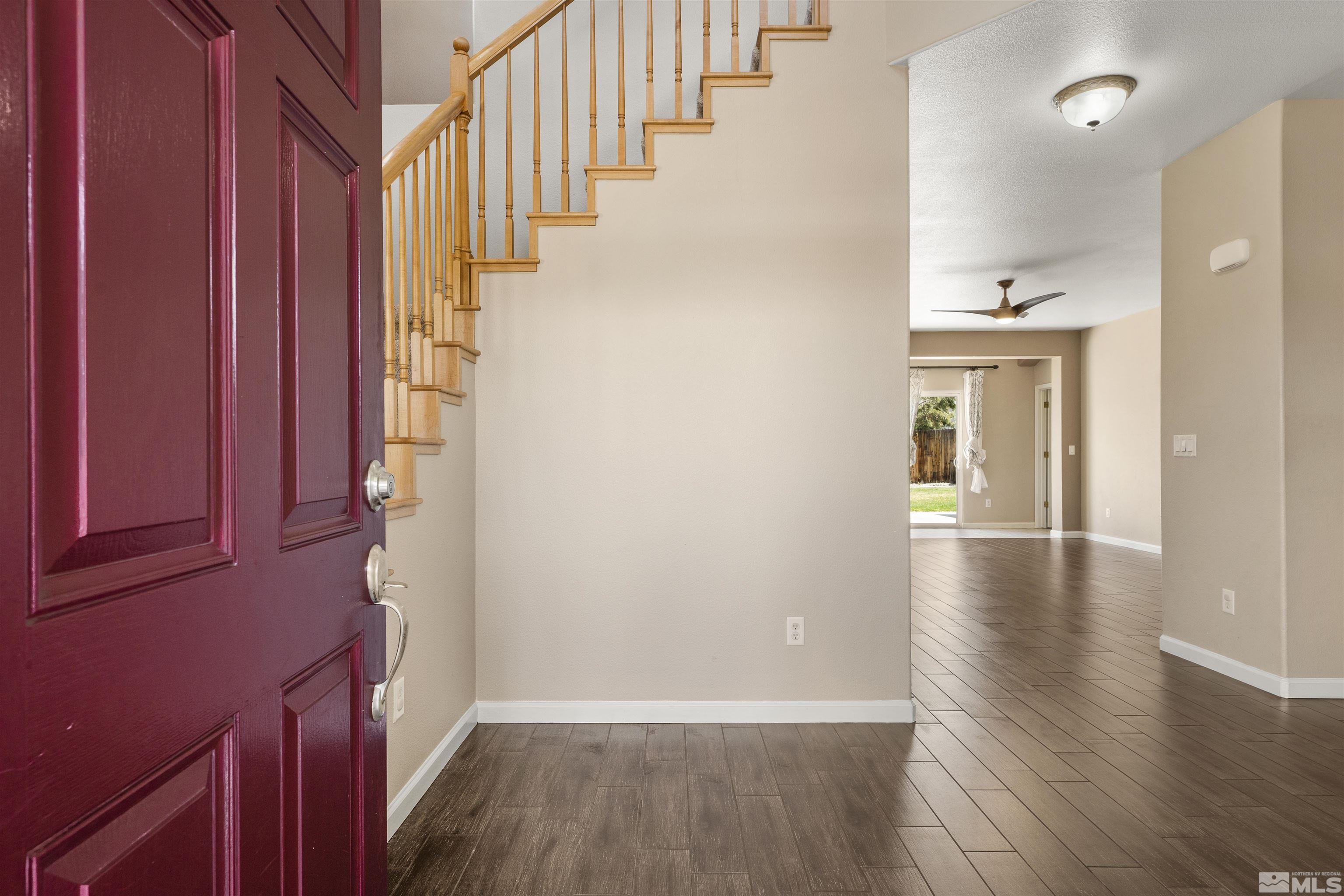10200 Wolf Ridge Way Reno, NV 89521 - Photo 2 of 40 a view of a hallway with wooden floor and staircase